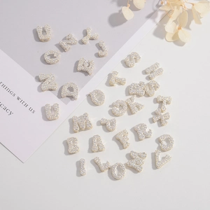 Macro detail of S925 silver A-Z alphabet charms with sparkling micro-pave cubic zirconia