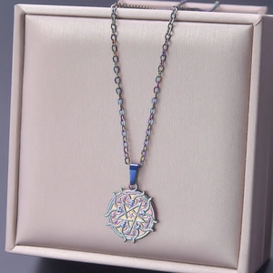 Detailed close-up of iridescent goat head and pentagram pendant on a gold cross chain