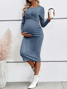 Close-up of blue ribbed knit maternity dress featuring an elegant twist knot neckline