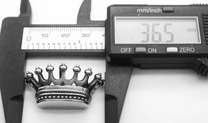 Macro shot of crown pendant size measurement showing 36.5 mm width on digital caliper