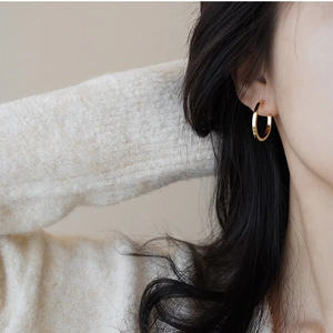 Eleganti orecchini a cerchio in oro lucido per donna indossati da una modella