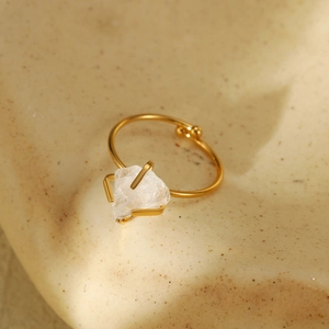 Macro detail of adjustable gold titanium steel ring with raw natural stone element