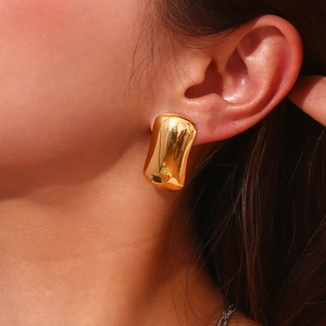 Close-up of 18K gold plated stainless steel geometric earrings on model's ear
