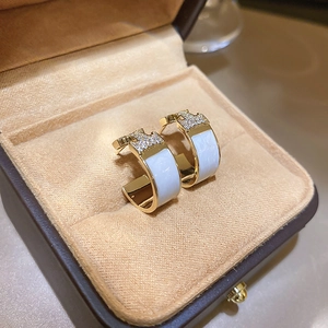Gold-plated C-shaped stud earrings with zircons in a brown velvet jewelry box