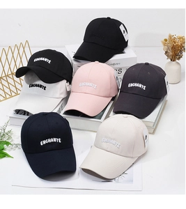 Detail of multi-color baseball caps with embroidered letters on a minimalist display