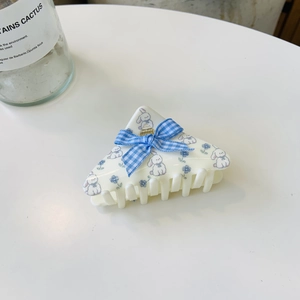 Detailed view of white triangle hair claw clip with blue plaid bow and floral bunny print