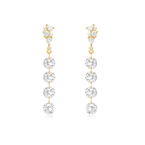 Macro shot of long gold earrings with tassel design and sparkling cubic zirconia stones