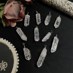 Macro display of natural white crystal hexagonal pillars with silver wire wrap detail