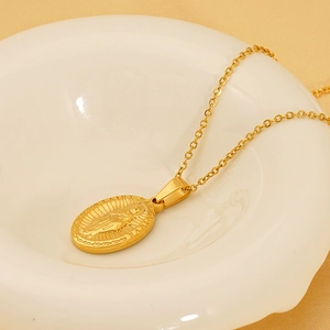 Gold-plated Saint Jude religious pendant necklace on a white ceramic tray, stainless steel