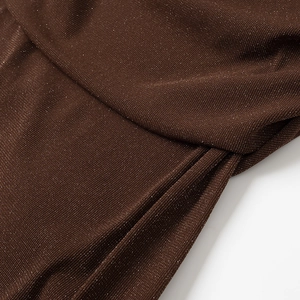 Detailed macro view of dark brown knitted fabric texture with subtle glitter sparkles
