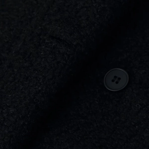 Women's black wool blend coat featuring textured lamb fleece fabric and resin button