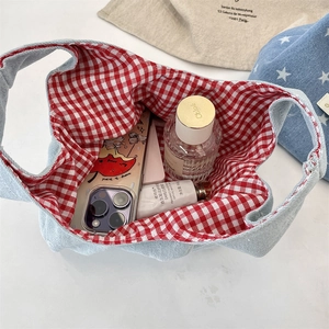 Internal view of denim tote bag with red checkered lining showing large storage capacity