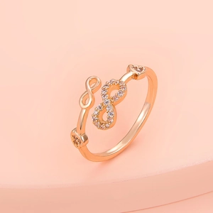 Detail of rose gold infinity ring with white cubic zirconia on a minimalist pedestal