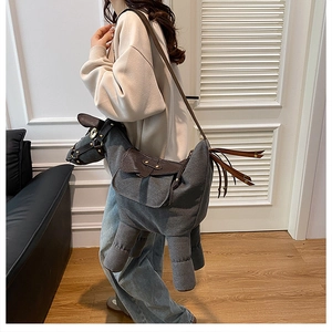 Detailed view of gray canvas donkey-shaped crossbody bag with brown faux leather accents