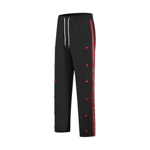 Detail of men's casual pants with red plaid side stripe and decorative buttons