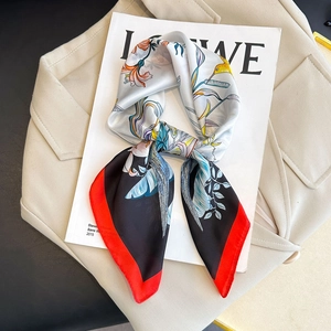 Elegant floral print silk scarf tied in a bow on a fashion magazine and beige coat