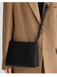 Minimalist black leather crossbody square bag for women worn with a khaki blazer