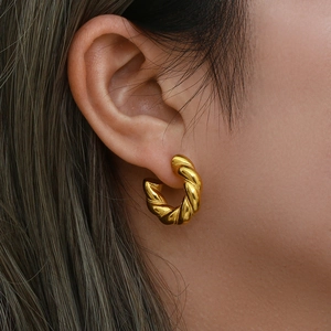 Close-up of 18K gold plated stainless steel twisted hoop earrings on a female model