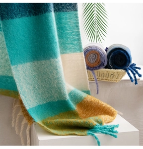 Close-up of soft mohair plaid scarf showing teal, beige and ginger fluffy textures