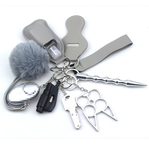 Detailed close-up of gray self-defense keychain set components on white background