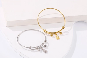 Detail of adjustable guitar charm bracelets in polished gold and silver finishes