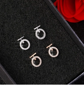 Close-up of pavé crystal round stud earrings in silver and rose gold finishes