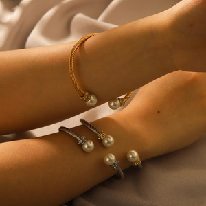 Detail of twisted cable bangles in gold and silver with pearls and crystals