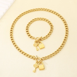 Ensemble collier et bracelet à maillons dorés avec pendentifs clé fleur et cadenas