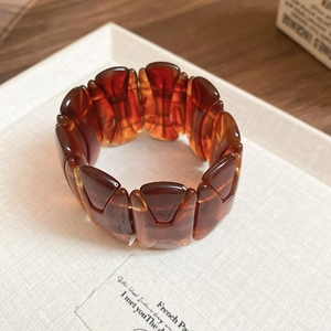 Detailed close-up of a wide amber resin bangle with stylish tortoiseshell patterns