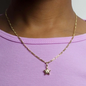 Gold stainless steel Figaro chain necklace featuring a unique star face pendant on a model