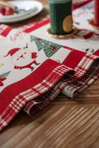 Detailed weave texture of a Christmas table runner with festive Santa and tree patterns