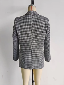 Detail view of the back seam and black and white houndstooth pattern on a blazer
