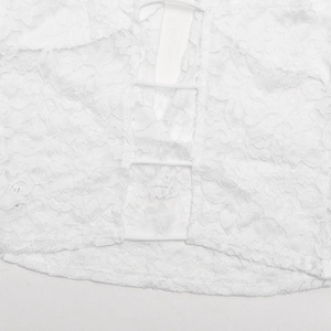 Détail du haut en dentelle blanche avec motifs floraux et design ajouré à lacets élégant