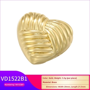 Macro shot of gold heart pendant with radial pleated texture and brass material detail