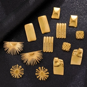 Detailed view of polished gold stainless steel geometric earrings on a glitter background