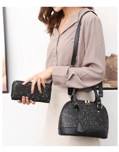Detail of black shell handbag and matching long wallet with shimmering golden sparkles