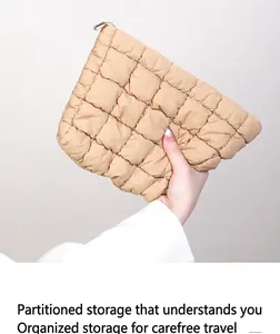 Vue détaillée d'une trousse de maquillage beige matelassée et plissée souple.