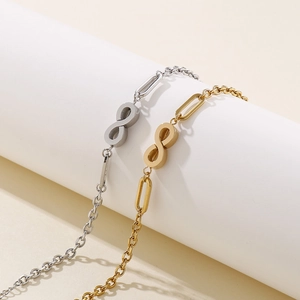 Minimalist infinity symbol chain bracelet in gold and silver finish on white stand