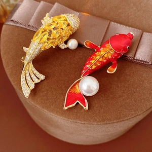 Detailed view of koi carp pearl brooches with enamel and zircon on a velvet gift box