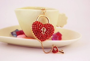 Detail showing heart-shaped lock and key keychain with sparkling red rhinestones