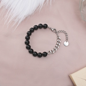 Detail of beaded bracelet with black lava stone and silver stainless steel chain link