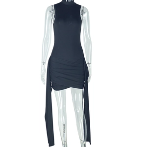 Detail of ruched hem and long decorative ties on a black sleeveless bodycon dress