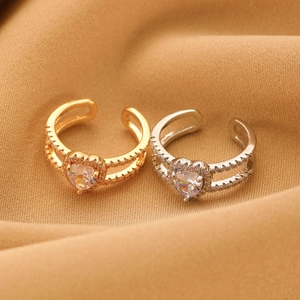Detail of gold and silver double-layered open rings with heart-shaped zirconia stones