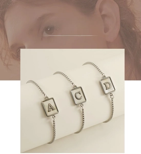 Detailansicht verstellbarer Edelstahl-Armbänder mit Muschelbuchstaben-Anhängern A C D