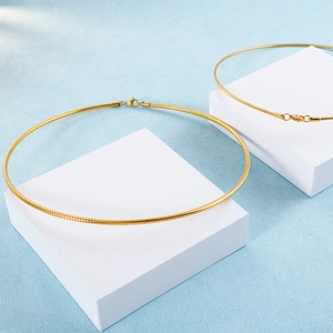 Detail of gold snake chain necklaces with lobster clasp on geometric display stands