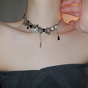 Detailed close-up of a Y2K silver necklace featuring heart, bow, and pearl charms