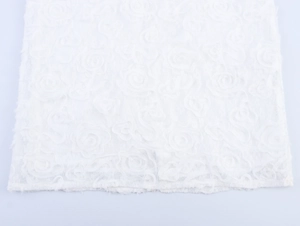 Dettaglio macro dell'elegante trama a rose 3D bianche sul tessuto del vestito attillato