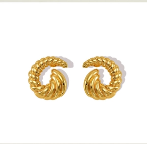 Detailed macro view of gold-plated stainless steel spiral twisted C-shape earrings