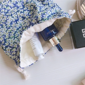 Detailed close-up of blue floral cotton drawstring pouch with soft white daisy print