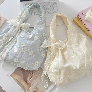 Detail of floral lace embroidery and sheer ribbon bow on aesthetic canvas tote bags